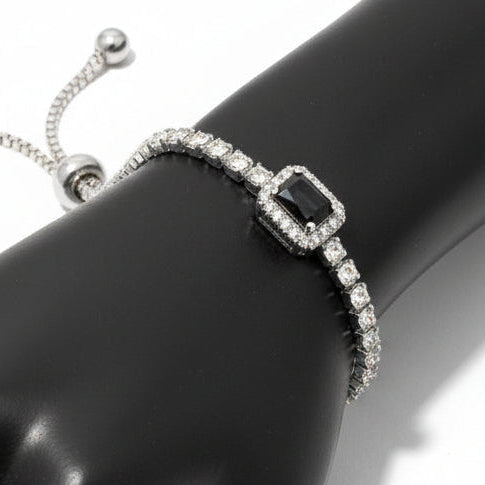 Silver bracelet with a black gemstone on a gray background