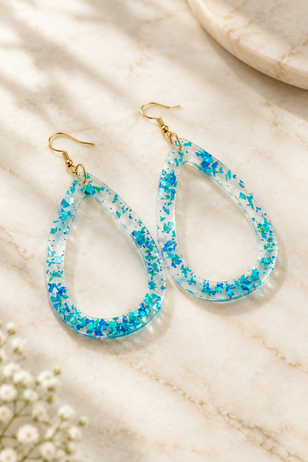 Iridescent Open Teardrop Earrings on cream marble