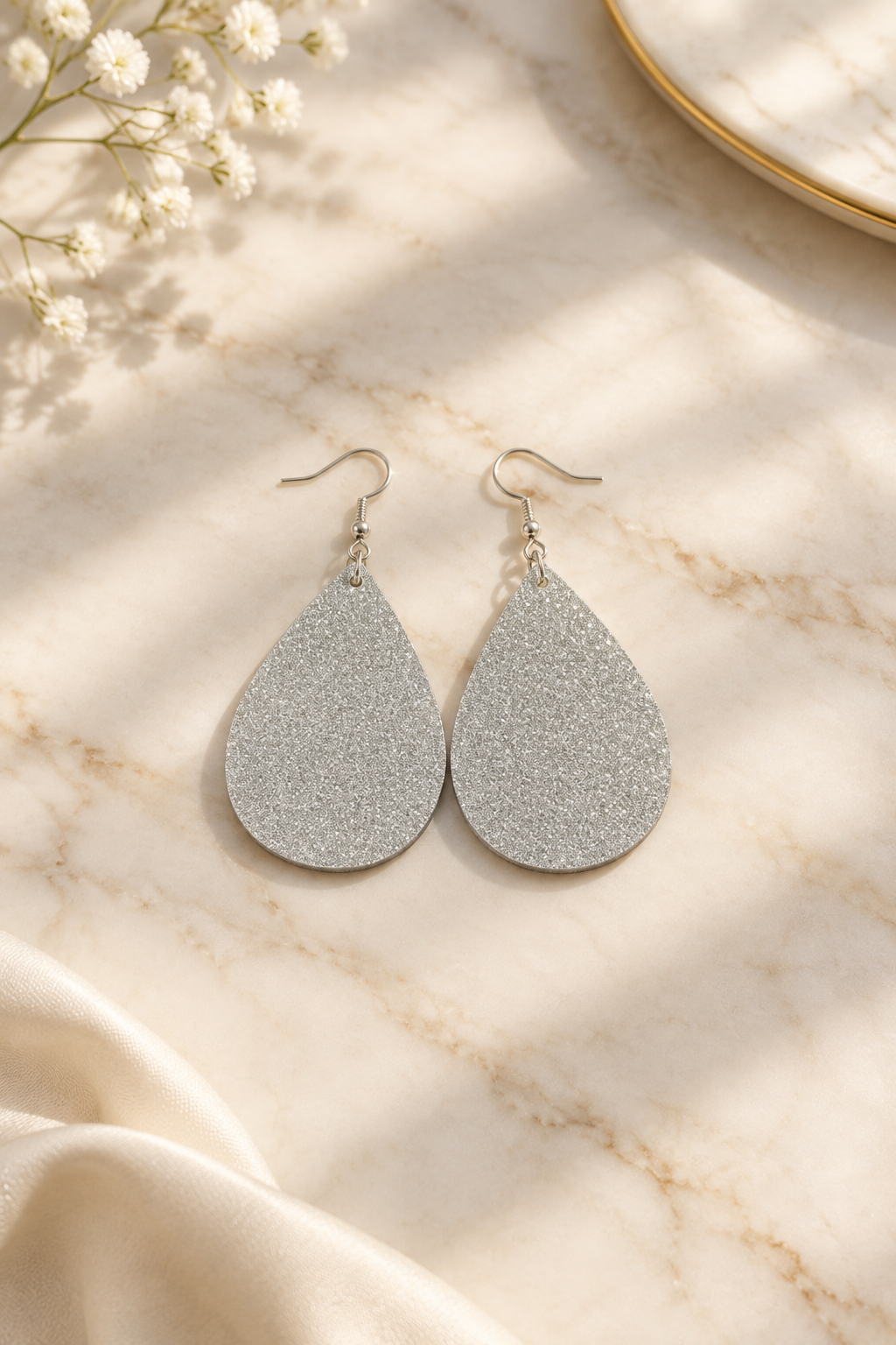 Shimmer Resin Teardrop Earrings on cream marble