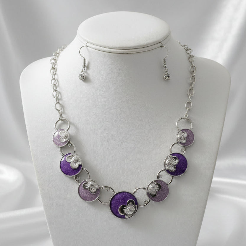 Necklace and earrings set with purple and silver circular pendants on a dark background