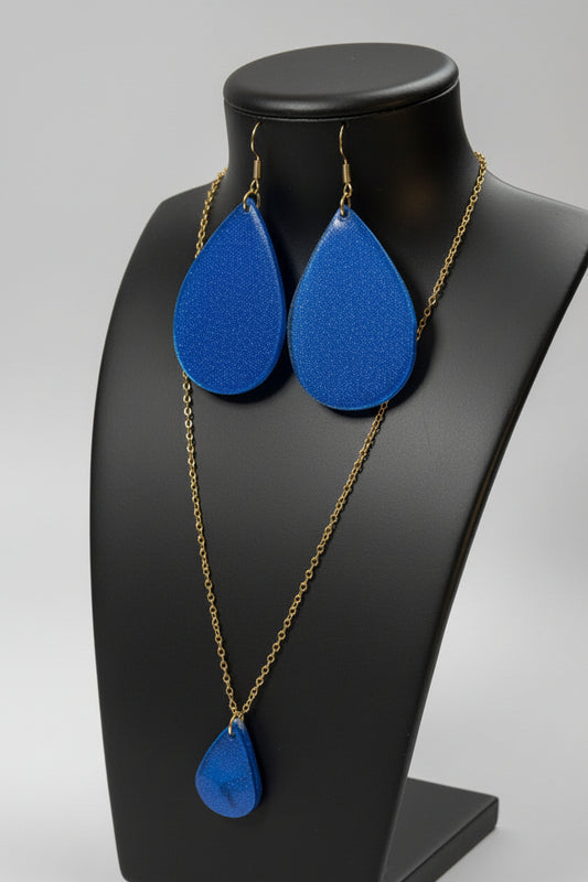Blue teardrop earrings with gold chains on a black mannequin bust.