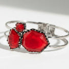 Silver bracelet with red hexagonal stones on a white background