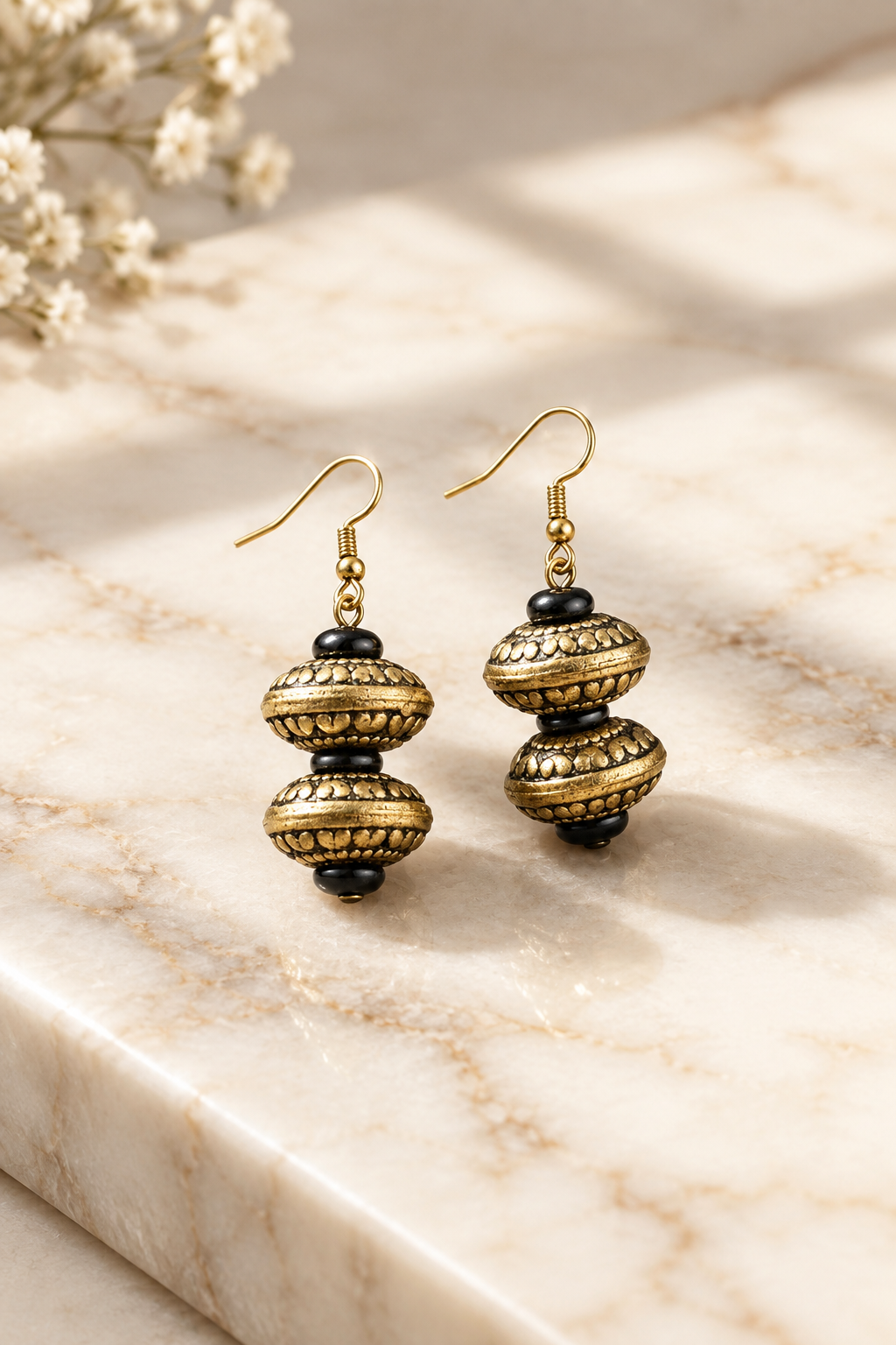 Antique Gold Tribal Earrings on cream marble