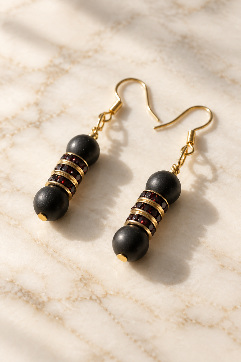 Black & Gold Bead Dangle Earrings on cream marble
