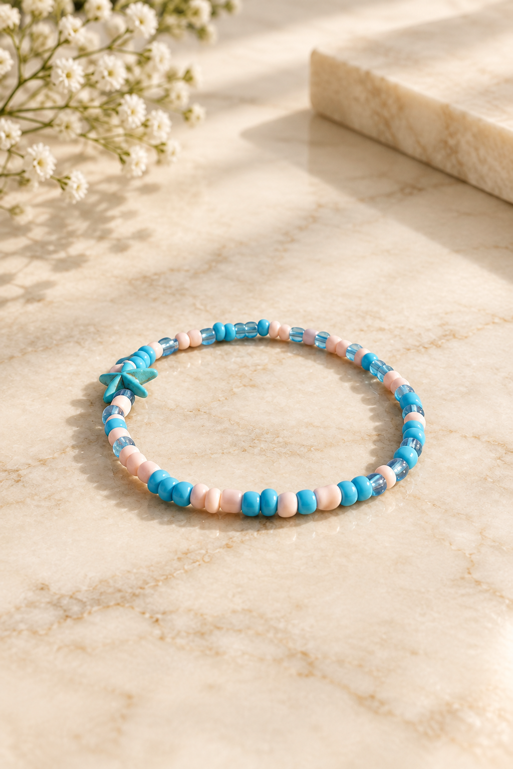 Blue Coastal Starfish Stretch Anklet on cream marble