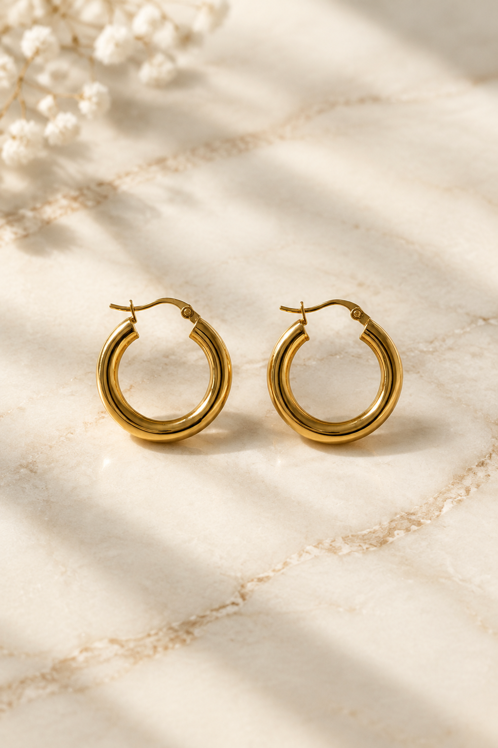 Classic Stainless Steel Hoop Earrings on cream marble