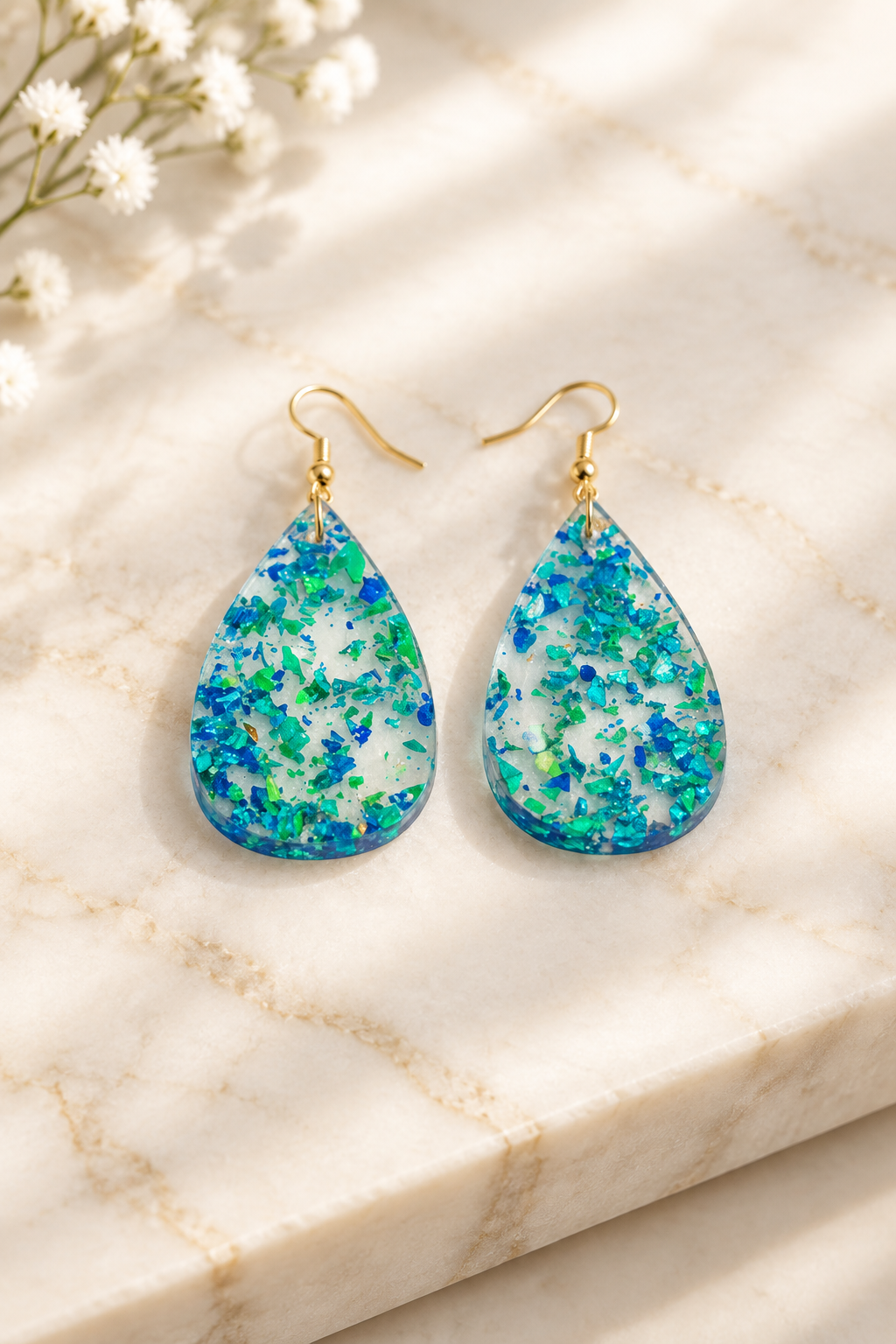 Iridescent Blue/Green Teardrop Earrings on cream marble