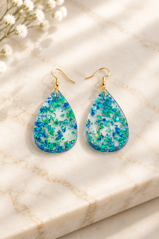 Iridescent Blue/Green Teardrop Earrings on cream marble