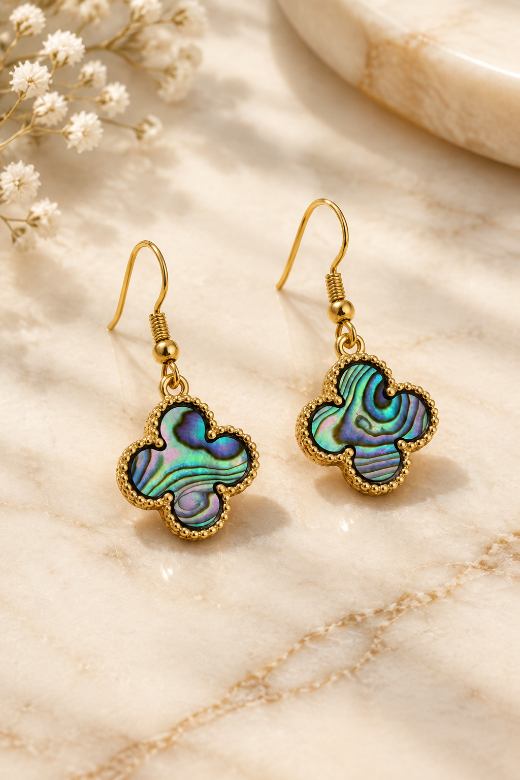 Iridescent Clover Abalone Earrings on cream marble